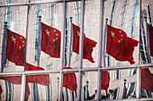 Chinesische Flaggen spiegeln sich in den Fenstern von Bürohochhäusern, Peking, China