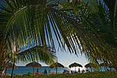 Touristen entspannen sich am Strand von Ancon (Playa Ancon) bei Sonnenuntergang, Trinidad, Kuba