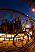 Fahrrad gegen Drahtzaun in der Abenddämmerung, Kölner Dom im Hintergrund, Köln, Deutschland