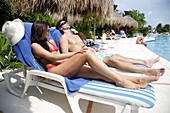Junges Paar beim Sonnenbaden am Swimmingpool, Riviera Maya, Yucatan-Halbinsel, Staat Quintana Roo, Mexiko