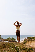 Frau auf Klippe mit Blick auf Meer, Rückansicht, Ditch Plains, Montauk, Long Island, New York, USA