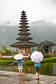 Tourists With Umbrellas At Temple