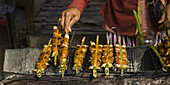 A Hand Turns Skewers On A Grill; Preah Dak, Siem Reap Province, Cambodia