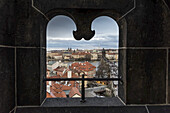 Blick auf die Stadt Prag, gerahmt durch ein einzigartig geformtes Fenster; Prag, Tschechien