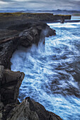 Große Wellen plätschern gegen die Klippen von Dryholaey, Südisland; Island