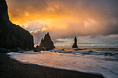 Die als Reynisdrangar bekannten Meeresstapel mit Wellen bei Sonnenaufgang, Südküste; Island