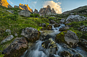 Sonnenaufgang über einem Gebirgsbach in den italienischen Dolomiten; Cortina, Italien