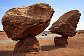 Geologische Formation 'Balancing Rocks' in der Nähe von Lee's Ferry, Az auf indianischem Land, gesehen im Hochsommer mit einem Auto auf dem Highway und blauem Himmel dahinter; Arizona, Vereinigte Staaten von Amerika
