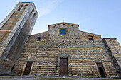 Niedriger Blickwinkel auf die Vorderseite des antiken Doms von Montepulciano mit blauem Himmel; Toskana, Italien