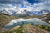 Der Lac Blanc spiegelt den Himmel, mit dem Mont Blanc Massiv und dem Refuge du Lac Blanc im Hintergrund; Chamonix-Mont-Blanc, Haute-Savoie, Frankreich