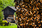 Nahaufnahme von gestapeltem Brennholz und historischen Holzgebäuden im Dorf Praz de Fort; Praz de Fort, Val Ferret, Schweiz