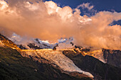 Wolken über dem Mont Blanc und Bossons-Gletscher leuchten bei Sonnenuntergang, Alpen; Chamonix-Mont-Blanc, Haute-Savoie, Frankreich