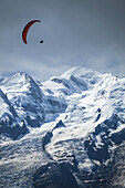 Ein Gleitschirm fliegt über den Mont Blanc; Chamonix-Mont-Blanc, Haute-Savoie, Frankreich.