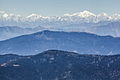 Layers of mountains in the Himalayas with snow-capped peaks in the distance; Nepal