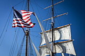 Amerikanische Flagge auf einem Segelboot vor blauem Himmel; San Diego, Kalifornien, Vereinigte Staaten von Amerika.