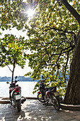 Zwei Motorräder, geparkt am Ufer der Ha Long Bay; Hanoi, Vietnam.