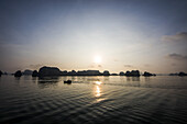 Kalksteinkarst und Inseln der Ha Long Bucht bei Sonnenuntergang; Quang Ninh, Vietnam.