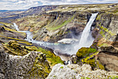 A high viewpoint of one of the waterfalls and rivers in the Haifoss valley with stunning cliffs, natural colors and rock formations; Iceland