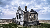 Ein abgenutztes Haus auf der Halbinsel Snæfellsnes in Island. Es gibt mehrere dieser Häuser, manchmal mit einem neueren Bauernhof in der Nähe oder, wie in diesem Fall, allein; Island