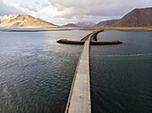 Mann steht auf einer Brücke in Island. Mit einer Drohne aufgenommenes Bild; Grundarfjorour, Island