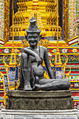 Bronze statue of seated man in hat; Bangkok, Thailand