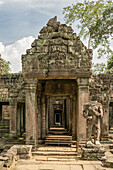 Stone temple portico guarded by headless statue, Preah Khan, Angkor Wat; Siem Reap, Siem Reap Province, Cambodia