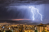 Stürmischer Himmel und Blitze über einer nächtlichen Stadt; Cochabamba, Bolivien