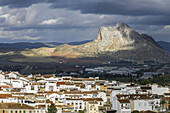 Schroffe Gebirgsformation und Häuser im Stadtbild von Antequera; Antequera, Malaga, Spanien