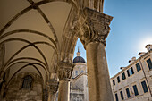 Detail of columns in the Rector's Palace facade and the Cathedral in the background; Dubrovnik, Dubrovnik-Neretva County, Croatia
