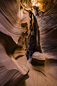 Man standing in a Slot Canyon known as Canyon X, near Page; Arizona, United States of America