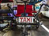 Cycle rickshaw with taxi sign; Havana, Cuba