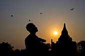 Silhouetten eines Mannes und eines buddhistischen Tempels; Bagan, Mandalay Region, Myanmar