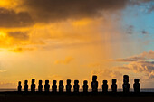 Die fünfzehn Moais von Tongariki vor dem farbenprächtigen Himmel des Sonnenaufgangs; Osterinsel, Chile.