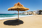 Strohdach wirft Schatten auf den Strand; Milos, Griechenland