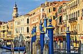 Colourful architecture along the Grand Canal with gondolas moored along the waterfront; Venice, Italy