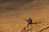 Couple taking a self-portrait on Dune 45, Sossusvlei, Namib Desert, Namib-Naukluft National Park; Namibia