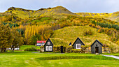 Ein Haus und ein Schuppen, die in einen grasbewachsenen Hang gebaut wurden; Rangarping, Südliche Region, Island