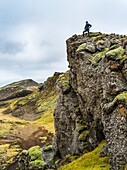 Eine Frau steht in der zerklüfteten Landschaft von Südisland; Grimsnes- og Grafningshreppur, Südliche Region, Island