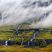 Wasserfälle, die über einen Berghang fließen; Djupivogur, östliche Region, Island