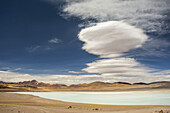Südamerikanische Hochgebirgslagune (kleiner See) mit linsenförmigen Wolken darüber; San Pedro de Atacama, Atacama, Chile