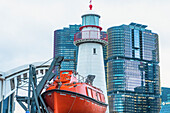 Straßenansicht von Sydneys Darling Harbour mit einem Boot und einem Leuchtturm; Sydney, New South Wales, Australien.