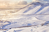 Weite, schneebedeckte, zerklüftete Landschaft in Island; Island