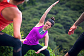 Women practice yoga at a coastal viewpoint in Raglan, New Zealand; Raglan, Waikato, New Zealand