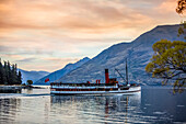 The famous TSS Earnslaw takes a sunset tour around Queenstown's Lake Wakatipu; Queenstown, Otago, New Zealand