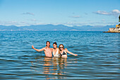 A group of friends play in the waters of New Zealand's Abel Tasman National Park; Tasman, New Zealand