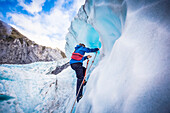 Reisende erkunden Neuseelands berühmten Franz-Josef-Gletscher. Blaues Eis, tiefe Gletscherspalten, Höhlen und Tunnel kennzeichnen das sich ständig verändernde Eis; Westküste, Neuseeland