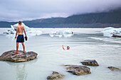 Men swimming in the icy glacial lakes of Mount Cook National Park; Canterbury, New Zealand