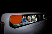 Gruppe von Reisenden kauert in ihrem Wohnmobil und spielt Spiele für den Abend, freies Zelten in der deutschen Stadt Kassel; Kassel, Deutschland