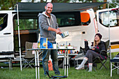 A stop for the night at a Czech Republic campsite between Prague and Cesky Krumlov. The 50 person town is called Kostelec and it is on the outsirts of Hluboka nad Vltavou. A camper prepares dinner for his friends; Kostelec, Vltavou, Czech Republic