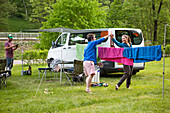 Camper spielen Badminton neben ihrem Wohnmobil auf einem Campingplatz außerhalb des Stadtzentrums der kleinen mittelalterlichen Stadt Cesky Krumlov in der südböhmischen Region der Tschechischen Republik; Cesky Krumlov, Böhmen, Tschechische Republik